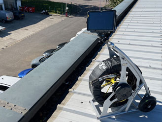 CCTV drain camera deployed on an industrial roof in Hackney, London, inspecting gutter drainage for blockages.