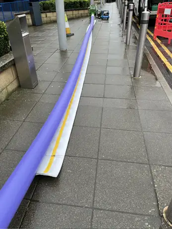The pre-prepared drain liner being pulled into position along the pipe run.