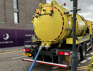 Jet and Drain vacuum tanker parked outside a Premier Inn in London while pumping waste from the on-site sewage pump station.